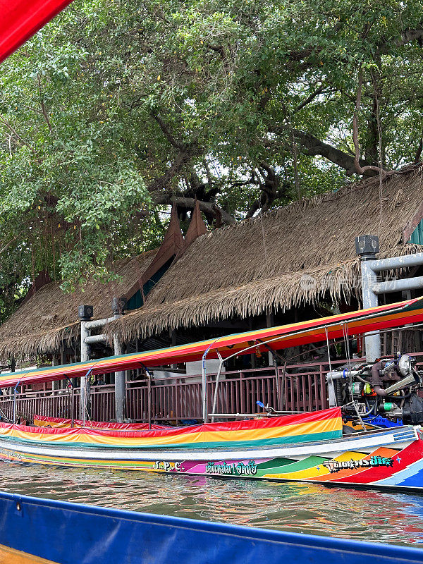 泰国拉差武里，一艘空木船，带着顶篷停泊在Khlong Damnoen Saduak运河的岸边，在Damnoen Saduak水上市场可以买到更高的价格